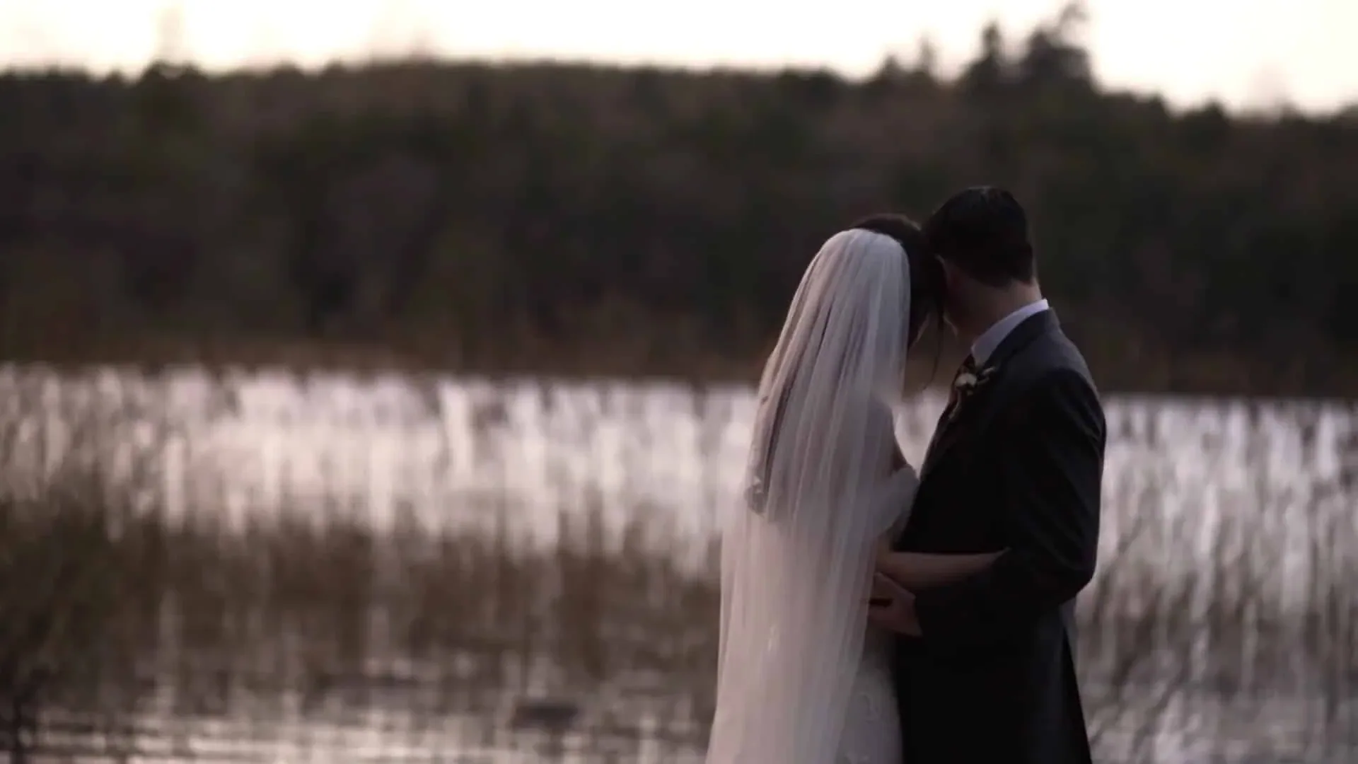 A bride and groom by the lake at Farnham Estate, Co. Cavan, at dusk