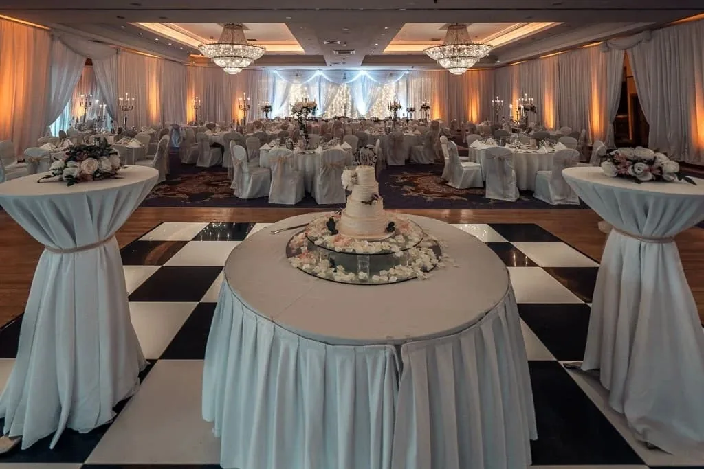 The ballroom at Knightsbrook Hotel set up for a wedding reception with a cake table on a chequered dance floor