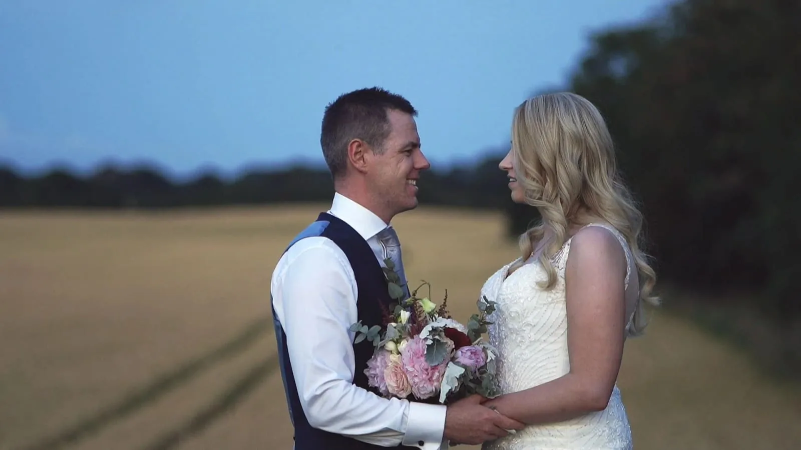 A bride and groom in a wheat field near Knightsbrook Hotel, Trim, Co. Meath, at dusk